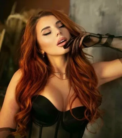 Red-haired OnlyMonster creator in a black corset
